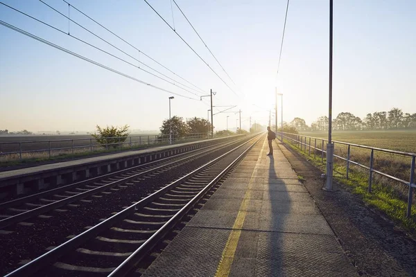 Güneş Doğarken Tren Demiryolu Istasyonunda Bekleyen Sırt Çantası Ile Yalnız — Stok fotoğraf