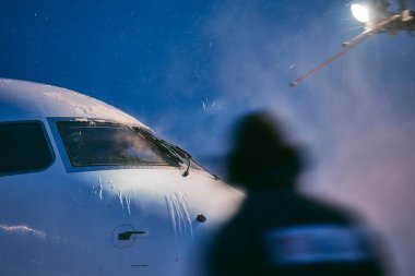 Winter morning at airport. Deicing of airplane before flight.  clipart