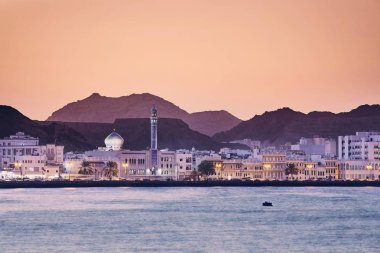 Cityscape kenti Muscat altın gün batımında. Umman'ın başkenti.