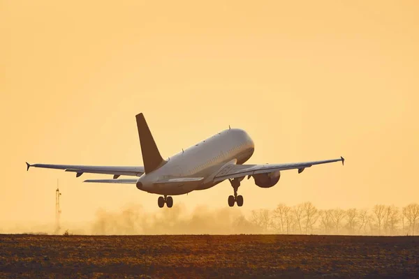 アット サンセット コピー スペース空港の滑走路から離陸する航空機 — ストック写真