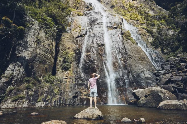 Młody Człowiek Turystycznych Stojąc Kamień Oglądania Strumienia Spadającej Wody Środku — Zdjęcie stockowe