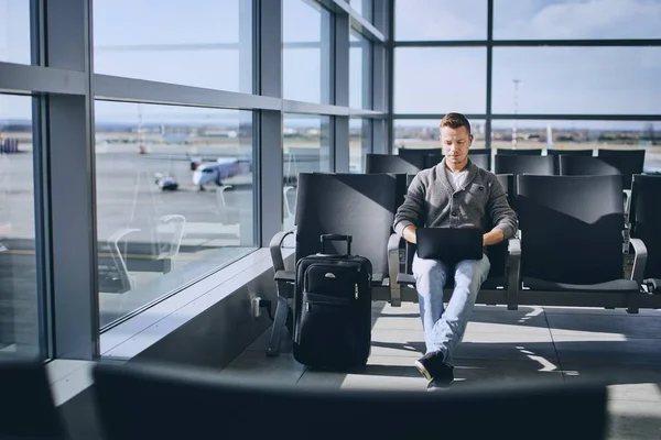 Ταξιδιώτης που χρησιμοποιούν φορητό υπολογιστή στο τερματικό σταθμό του αεροδρομίου — Φωτογραφία Αρχείου