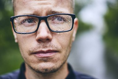 Yağmurda gözlüklü adam