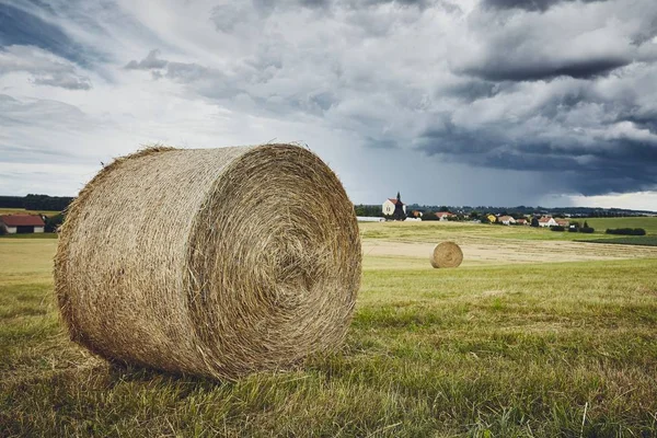 Straw bales stacked on field against storm — Stock Photo, Image