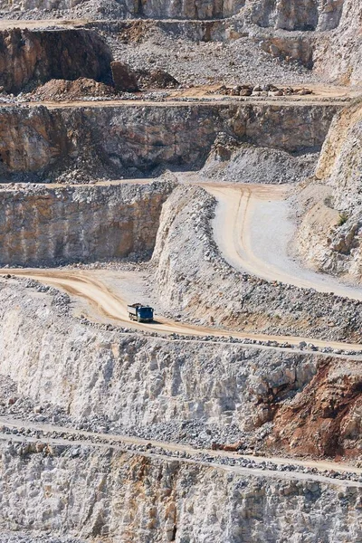 Industrial stone mining. Truck in the middle of huge quarry.