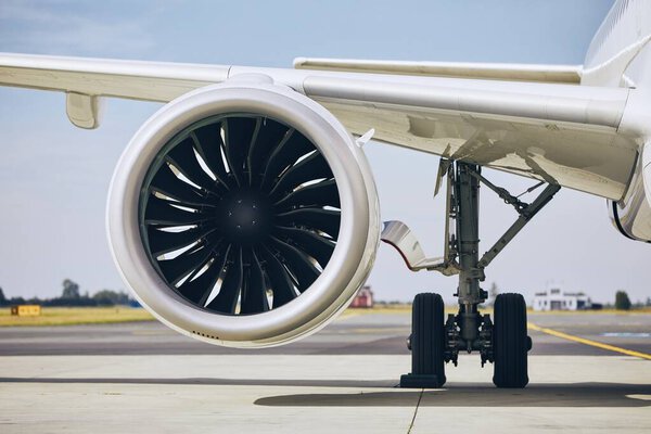 Jet engine of commercial airplane at airport during sunny day. Themes modern technology, power and travel.