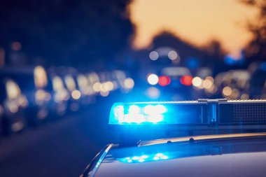 Caddedeki polis arabasının çatısında siren ışığı. Temalar suç, acil durum ve yardım.