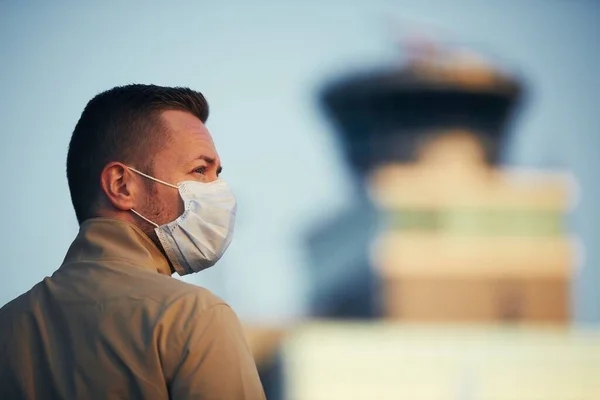 在机场戴口罩的男人主题是在新的正常的 验尸和个人防护中传播的 — 图库照片