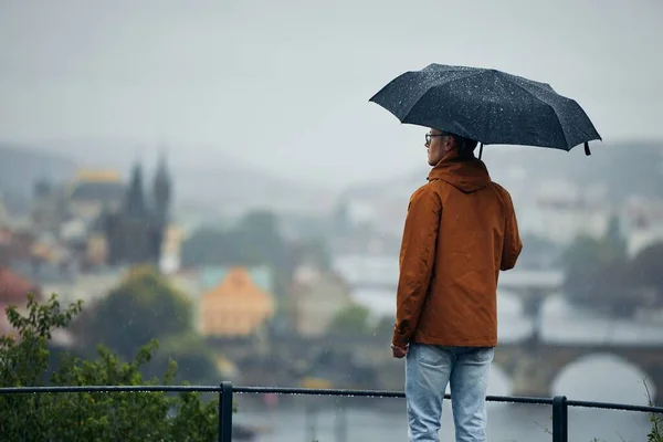 Egy Fiatal Férfi Esernyővel Aki Várost Nézi Heves Esőben Szomorú — Stock Fotó