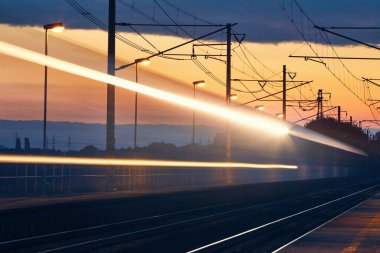 Şafak vakti demiryolu. Tren istasyonundaki yolcu treninin hafif patikaları.
