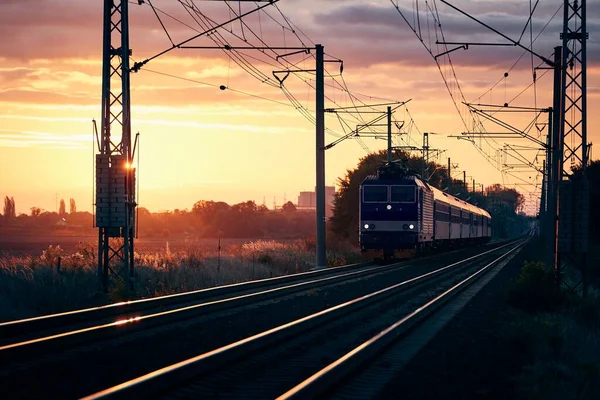 美しい日の出で鉄道軌道上の公共交通機関の旅客列車 — ストック写真