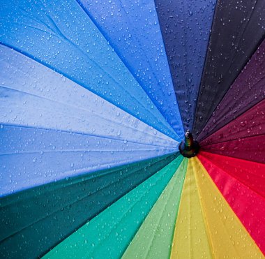 Yağmurdan sonra renkli şemsiyeye su damlıyor
