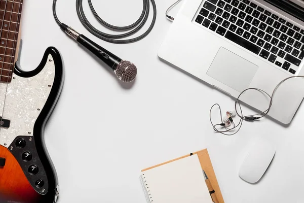 Üstten görünüm parlak beyaz Masaüstü Dizüstü, bilgisayar, klavye, gitar ve diğer öğeler. Müzik konsepti. Yukarı alay