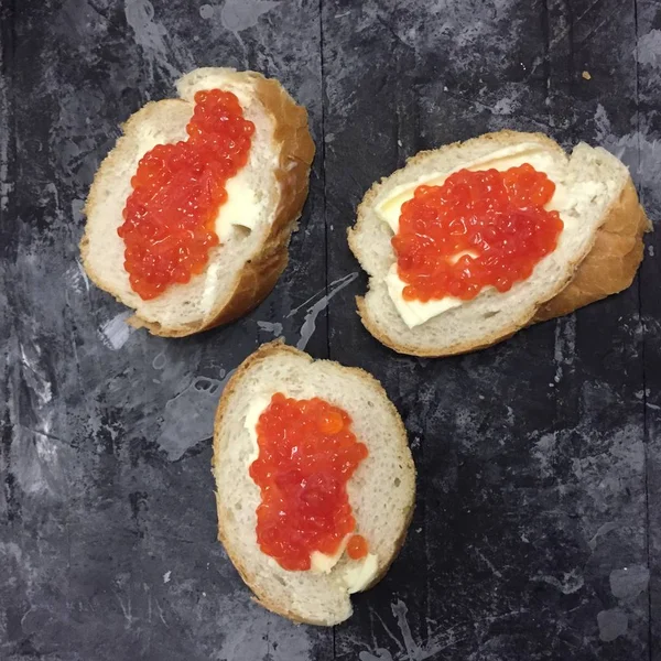 Eski püskü grunge arka plan üzerinde kırmızı havyar ve tereyağı tost