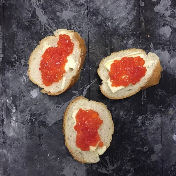 Eski püskü grunge arka plan üzerinde kırmızı havyar ve tereyağı tost