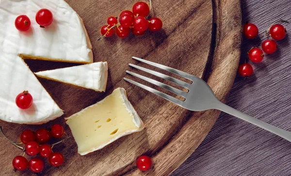 Cheese Bree with red currant on the carving board