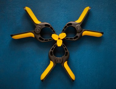 Mavi arkaplanda plastik yay kıskaçları, yakın plan