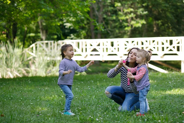 Mutlu anne ve kızı parkta. Aile açık hava yaşam tarzı ile bir güzellik doğa manzara