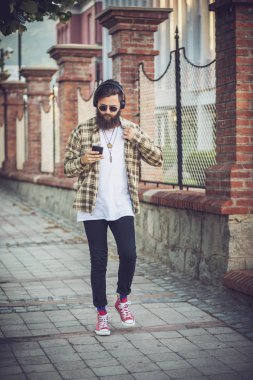 Üstünde belgili tanımlık sokak ve manifatura yürüyen genç adam.