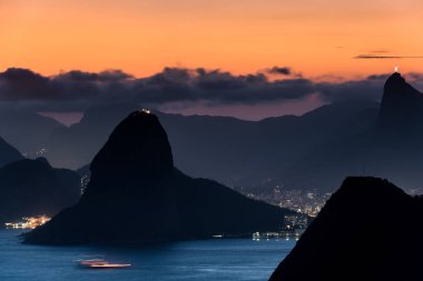 CopacabanaPlajı ışıklar gece ve Rio de Janeiro Dağları ile görünümünü