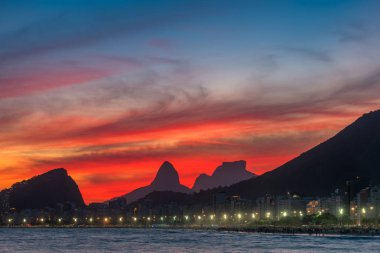 Gün Batımından Hemen Sonra Güzel Kırmızı Gökyüzü ile Copacabana Plajı Gece Görünümü, ve Ufukdağlar, Rio de Janeiro, Brezilya