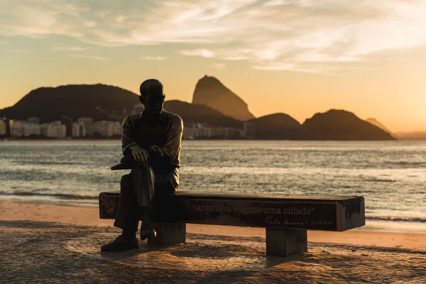 Rio de Janeiro, Brezilya-Temmuz 1, 2019: Brezilyalı şair Carlos Drummond de Andrade heykeli Sunrise tarafından Copacabana plajında bir bankta oturuyor