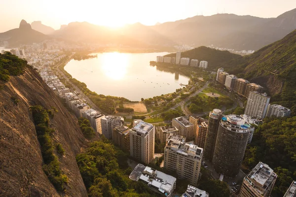 Brezilya 'nın Rio de Janeiro şehrinde Daire Binaları ve Dağlarla çevrili Sunset ile Rodrigo de Freitas Gölü' nün güzel manzarası