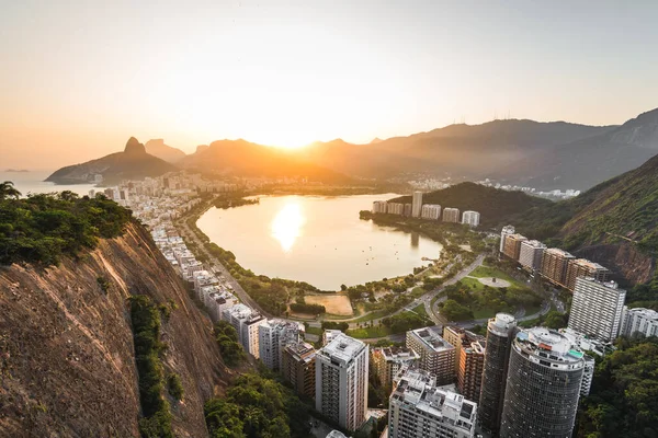 Brezilya 'nın Rio de Janeiro şehrinde Daire Binaları ve Dağlarla çevrili Sunset ile Rodrigo de Freitas Gölü' nün güzel manzarası