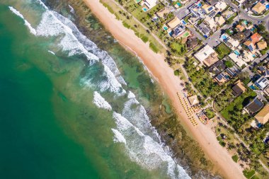 Bahia 'daki Salvador şehrinin yakınlarında, sahil boyunca kayalar ve resiflerle sahile çarpan dalgaların yukarıdan görünüşü