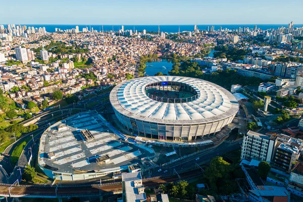 Salvador, Brazil - July 30, 2025: Aerial view of Fonte Nova Arena football stadium with city skyline and ocean in the horizon.