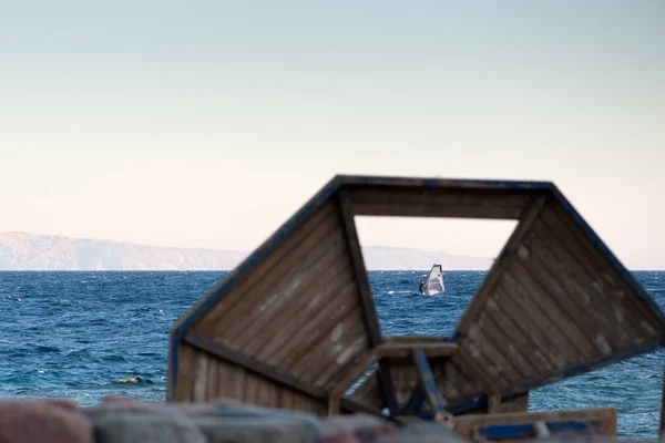 Dahab dolgu ahşap şemsiye eksik parçasını aracılığıyla gelen bir sörfçü kırmızı deniz manzaralı Gulf of Akabe'de rides