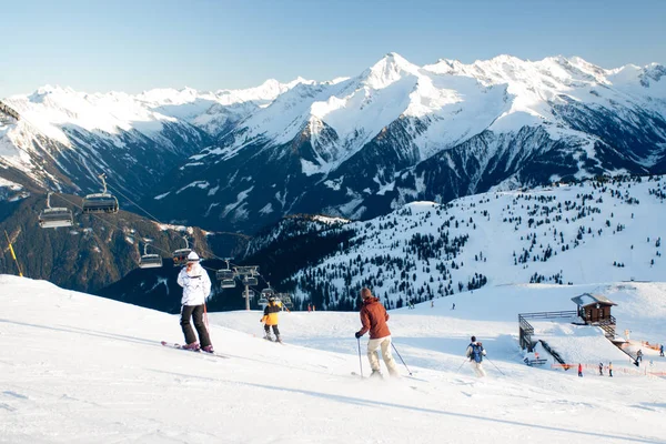 Ski lift ve kayak pisti ile mavi gökyüzü ile güneşli kış gününde altındaki kayakçı.