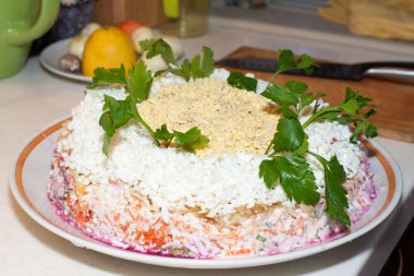 Bir kürk manto üzerinde büyük bir beyaz çanak altında geleneksel Rus salatası ringa yeşillik ile dekore edilmiştir.