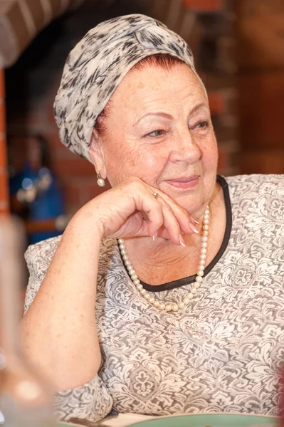 Portret van een elegante oudere dame, zit aan de tafel van de vakantie — Stockfoto