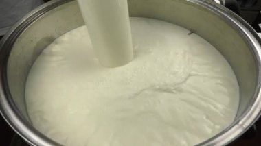 Pastörizasyon sütü ile sıcaklık sensörü ile donatılmış paslanmaz çelik bir tankın doldurulması