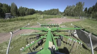 Çerçeve üzerinde bir rotor traktör tırmık yakın çekim kamera ile saman tornalama kurutma