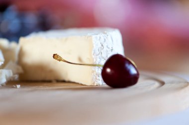 Keçi sütünden camembert tatlı kiraz çilek yakın çekim ile ahşap bir tahta üzerinde hala hayat dilimleri halinde kesilmiş