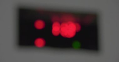 Yanıp sönen dijital sıcaklık ve nem göstergesi. Bulanık görüntü, semboller, kırmızı yanma ve yeşil yanıp sönen sayılar, gri çerçeveleme üzerinde düzgün odak. Sabit değer göstergeleri.