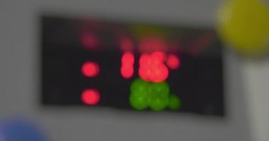 Yanıp sönen dijital sıcaklık ve nem göstergesi. Bulanık görüntü, semboller, kırmızı ve yeşil yanıp sönen sayılar, gri çerçeveleme, köşelerde mavi ve sarı mıknatıslar üzerinde düzgün odak. Göstergelerin değişen değeri.