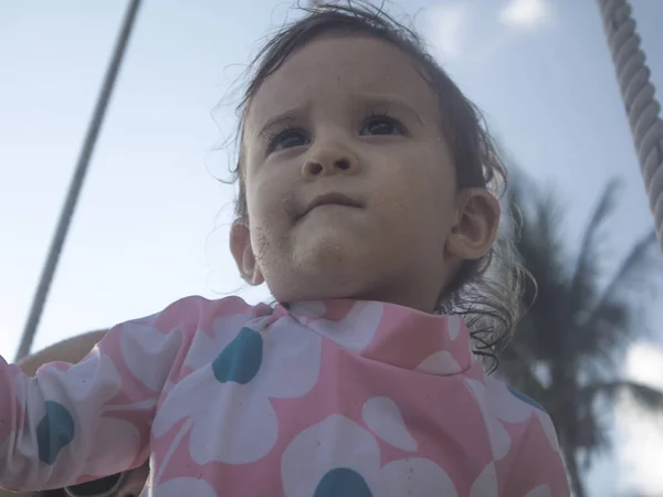 Kızı bir paketle ayakta sahilde veren anne zevk A yaz gün On The Beach ve yüzme poolmother.