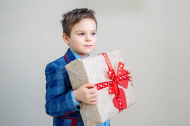 Açık renkli, st Sevgililer günü kavramı üzerinde bir hediye kutusu ile takım elbiseyle çok güzel çocuk