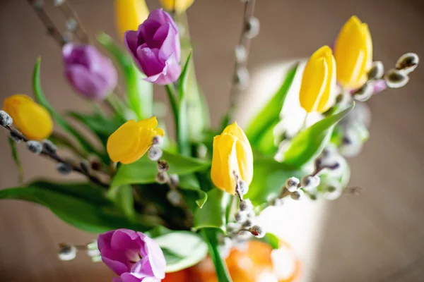Buquê de primavera brilhante de tulipas amarelas e roxas e ramos salgueiros buceta. Arranjo de Páscoa de flores frescas . — Fotografia de Stock