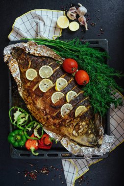 Fırınlanmış balık nehri sazan balığı aromatik otlar, baharatlar, tuz, sebzeler, limon, sarımsak, üst manzara, sağlıklı yiyecekler, diyet veya aşçılık konsepti.