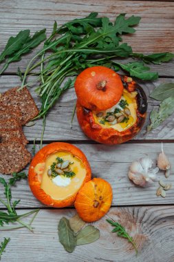 Balkabağı çorbası küçük balkabaklarında servis edilir. Sonbahar yemeği. Durgun hayat, üst manzara,