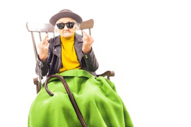 Şapka ve güneş gözlüğü sandalye örtmek ile yeşil blacket oturan yaşlı kadınla.