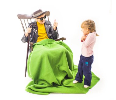 Yaşlı kadın güneş gözlüğü ve şapka onun torunu konuşuyor.