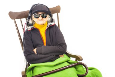 Şapka ve güneş gözlüğü sandalyede oturan yaşlı kadınla