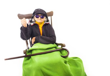 Şapka ve güneş gözlüğü sandalyede oturan yaşlı kadınla