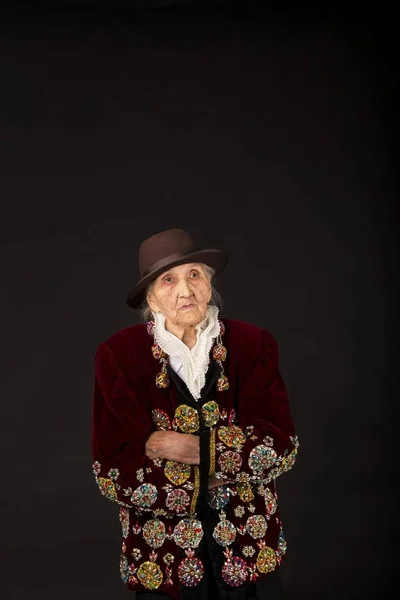 Stylish old woman on black background