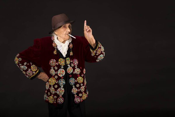 Стильная старуха на черном фоне
